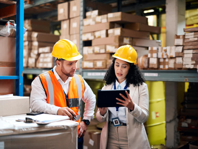 2 people wearing yellow hard hats talking
